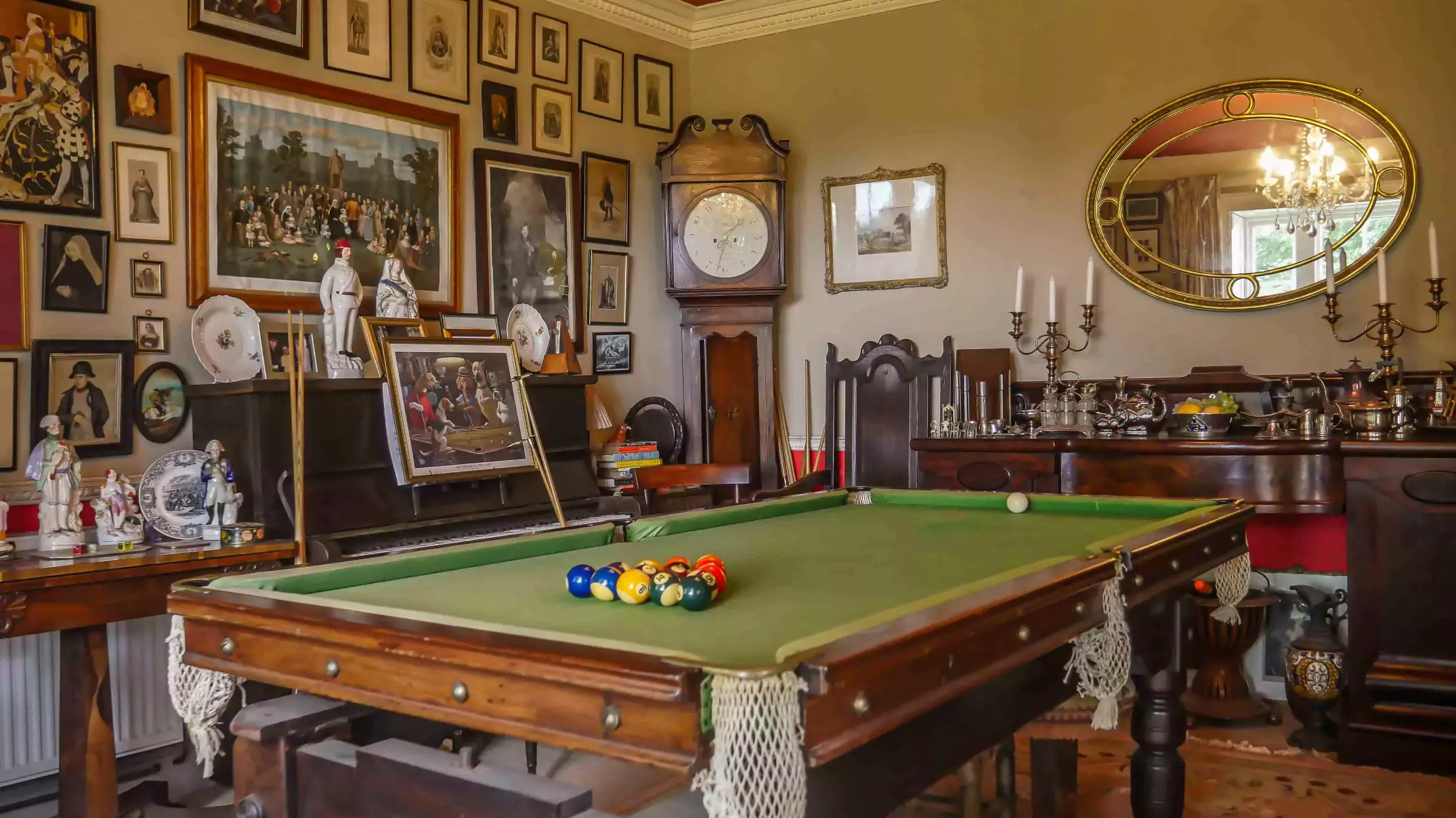 photo of dining room with snooker table in the middle surrounded by georgian furniture and pictures of the royal family