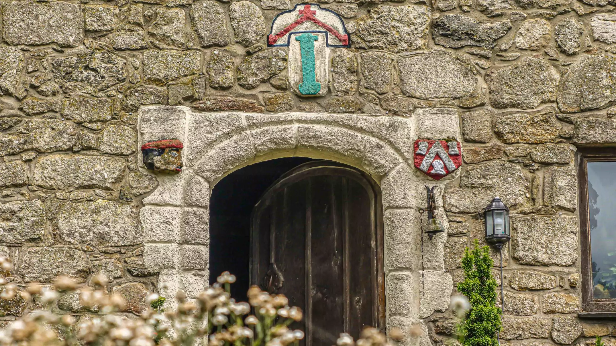 photo showing a close up of the front door surround by carvings of Owain Tudors Shield and Saracens head