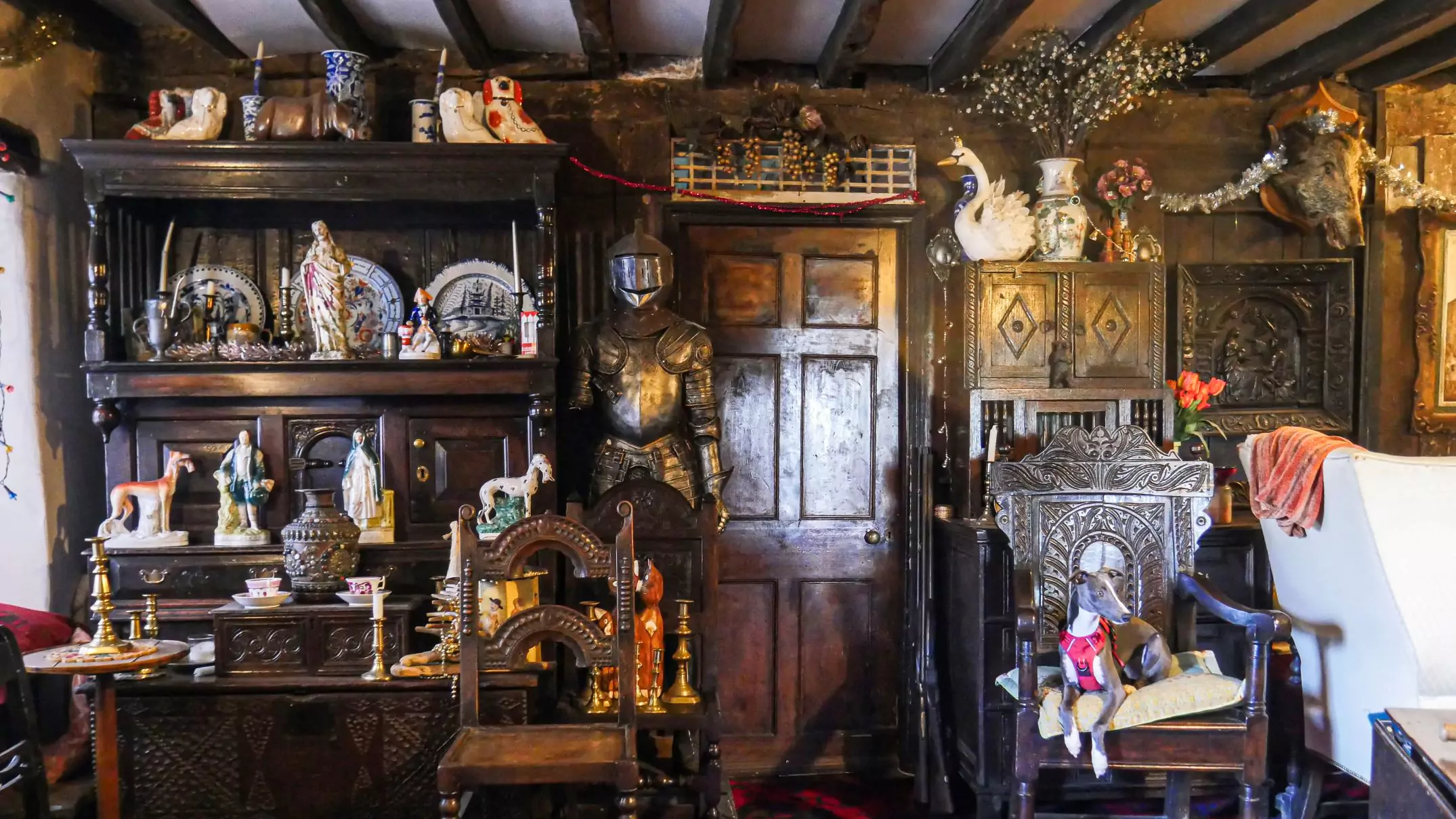 photo of the living room containing dark oak furniture and a suit of armour